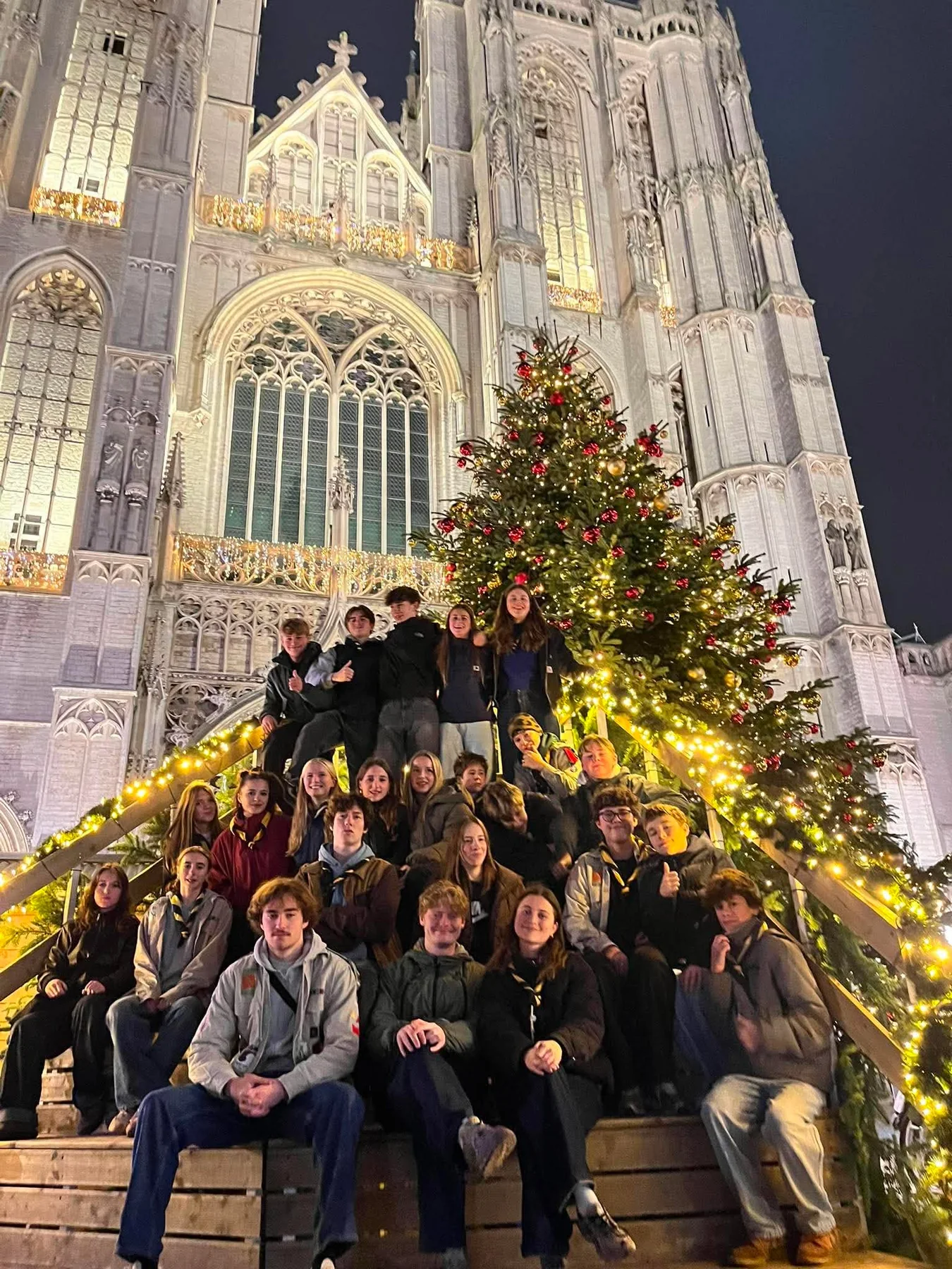 Givers samen bij de kerstboom aan de kathedraal