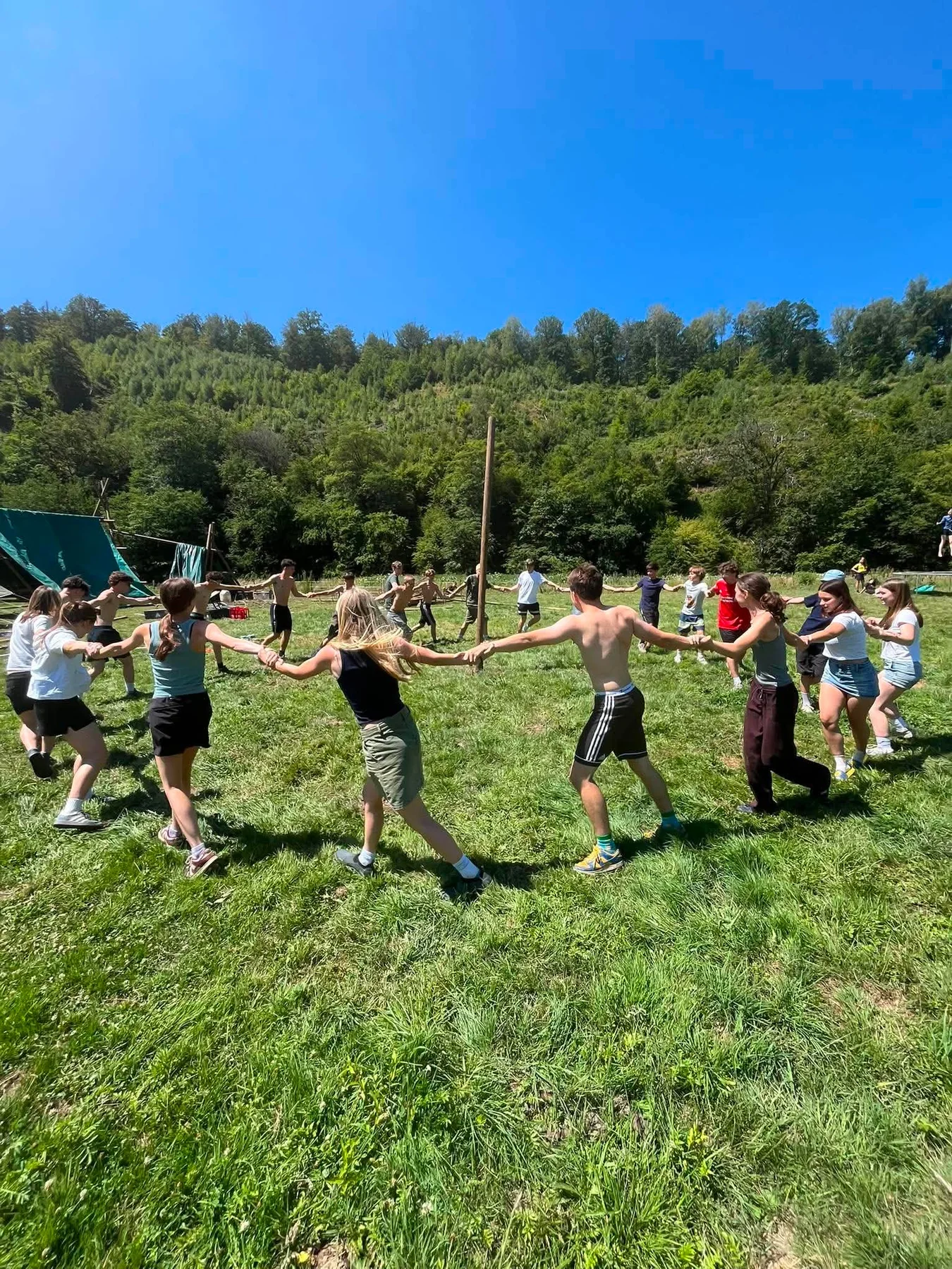Givers vormen samen een grote kring op kamp