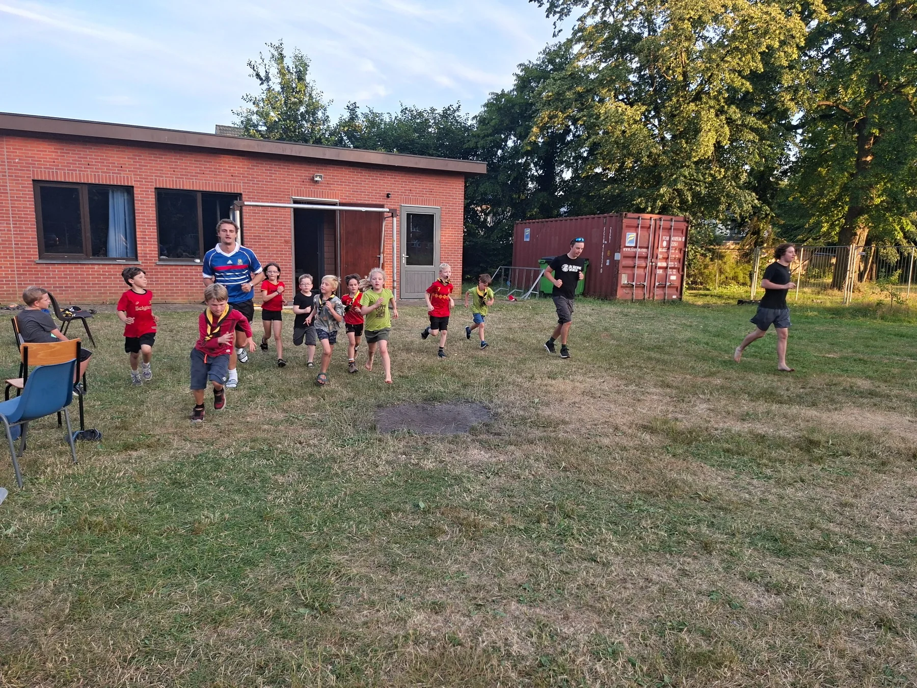 Scoutsleden tijdens een actief loopspel op het terrein