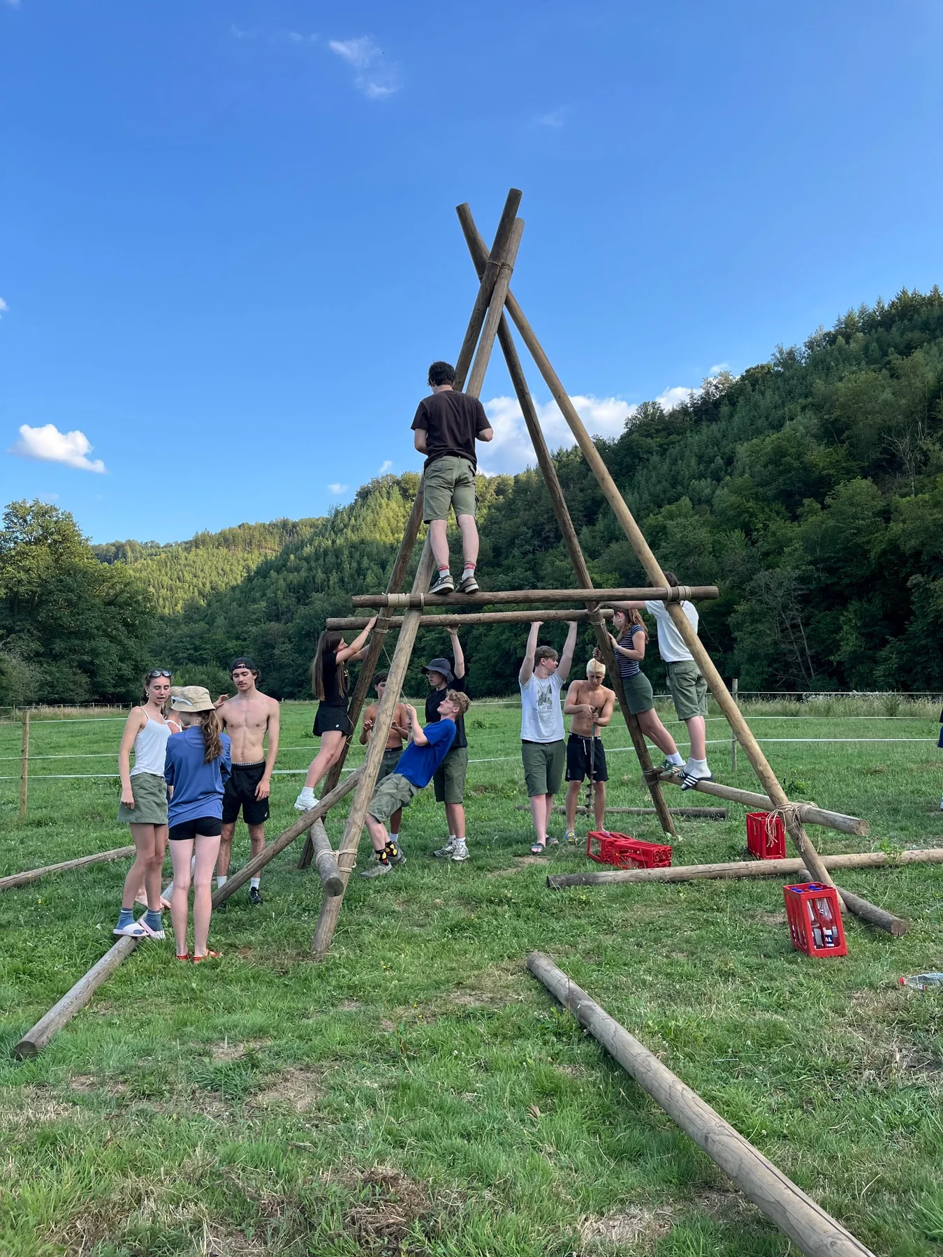 Scoutsleden bouwen samen een gesjorde constructie op kamp